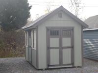 Pine Creek 8x12 Cape Cod with PC Green walls, Chestnut trim and Navajo White Z-Style shutters, and Brown metal roof